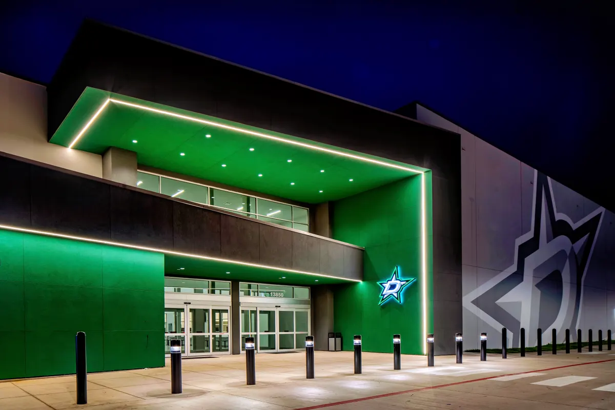 The main entrance at night, lit in Dallas Stars green